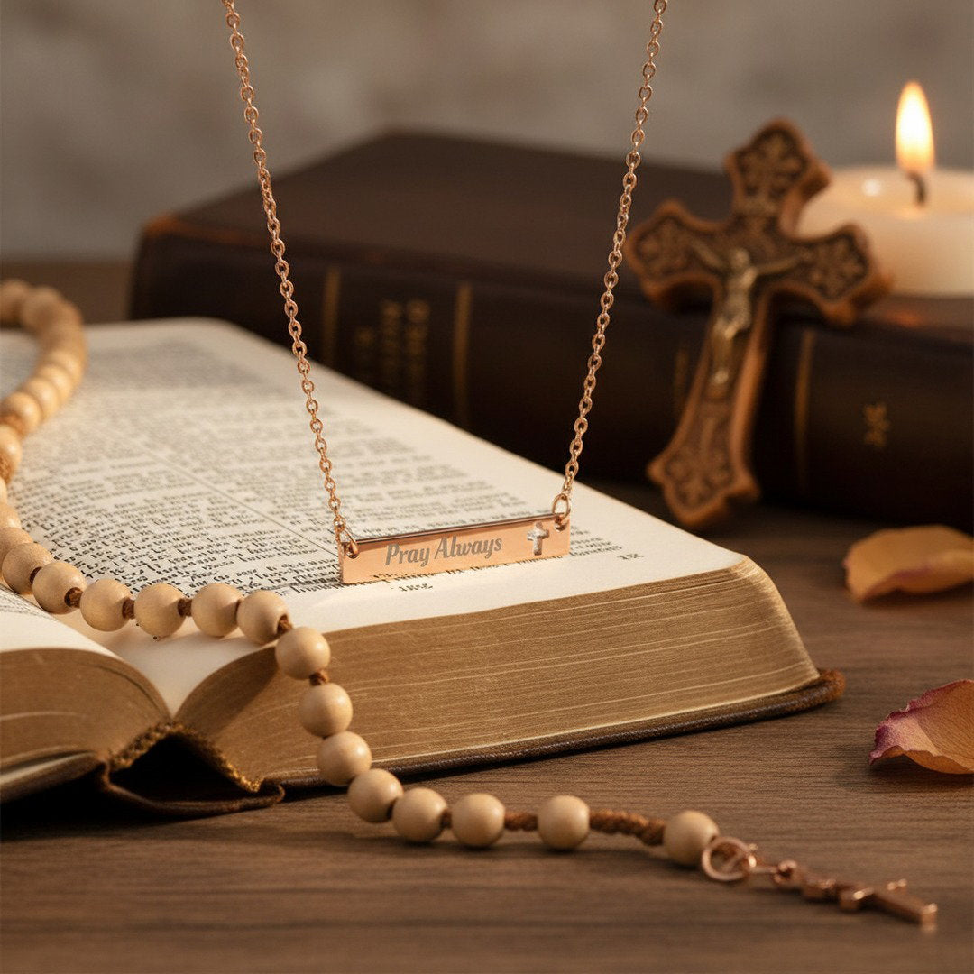 Rose gold Pray Always necklace on open Bible with cross and rosary, meaningful Christian gift for graduation