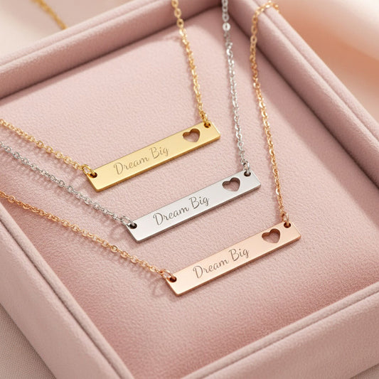 Dream Big bar necklaces in gold, silver, and rose gold layered in a blush pink velvet jewelry tray — inspirational gift necklace set