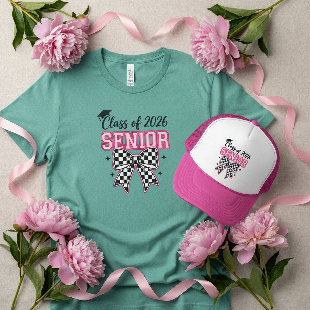 Class of 2026 Senior checkered bow t-shirt in seafoam green laid flat with pink and white Senior checkered bow trucker cap surrounded by pink peonies and pink satin ribbon on cream background, graduation t-shirt and hat bundle gift flat lay